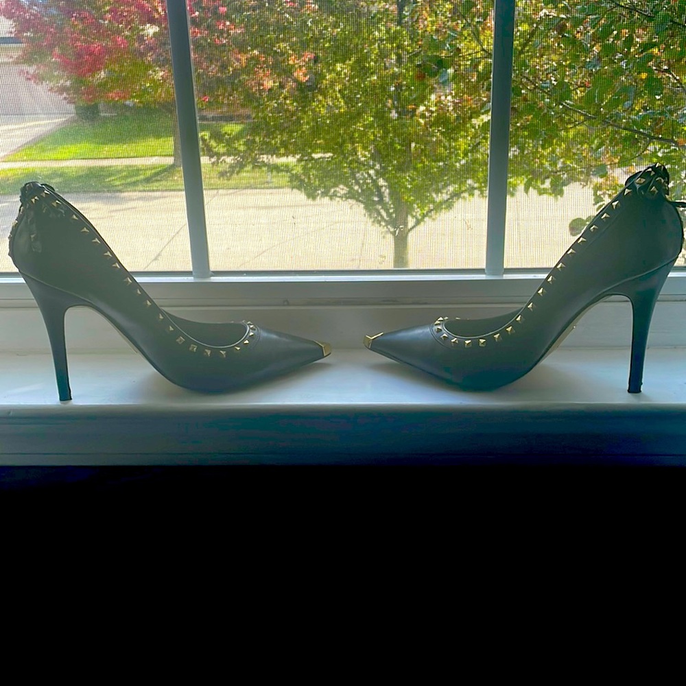 A pair of fabulous black heels with style with small studded bow in the back